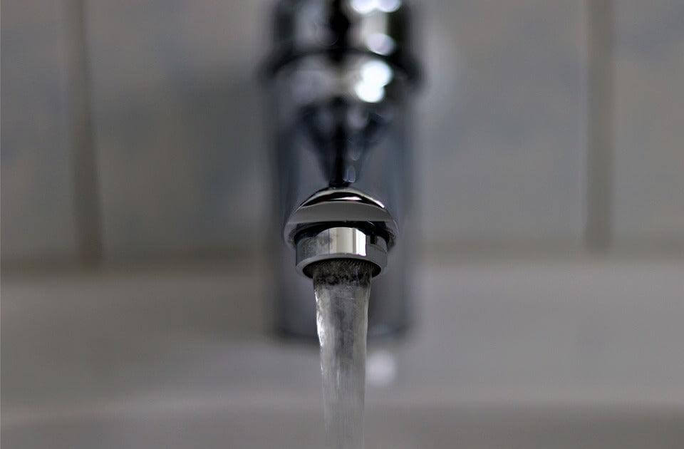 Chrome Wasserhahn mit laufendem Wasser in der Sanitäreinrichtung, geeignet für wasserenthärtungsanlagen